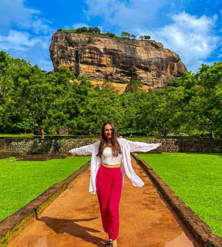 The,Beautiful,Girl,In,A,White,Shirt,And,Pink,Pants Student girl posing in front of the Sigiriya Rock Fortress in Sri Lanka.