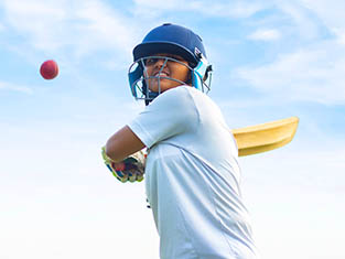 Teenage girl playing cricket
