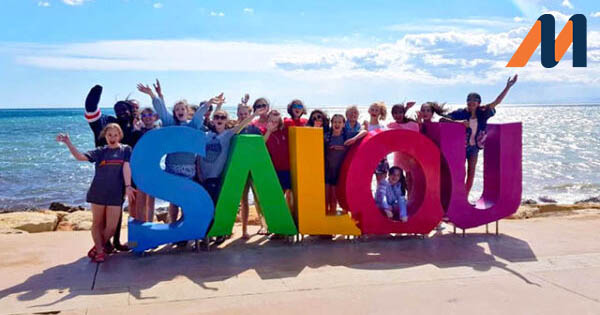 A MasterClass school group posing in front of the Salou sign on the beach in sunny Spain