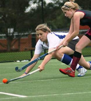 Girls playing hockey in a competitive match