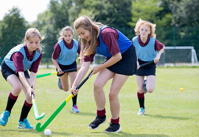 Girls playing field hockey