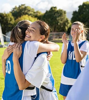 Girls football players celebrating after a win