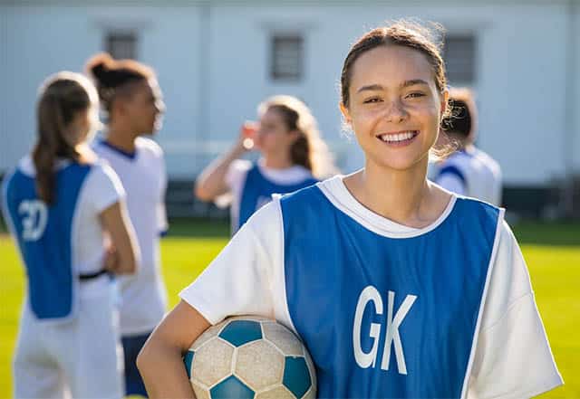 Girls Football is on the rise! Female football player smiling at the camera