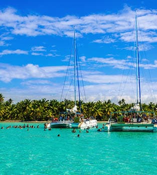 Catamarans,On,Azure,Water;,Caribbean,Holidays,,Caribbean,Islands Group snorkelling around their catamaran in the turquoise Carribean sea