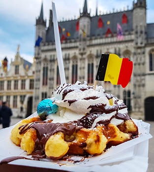 A Belgian waffle covered in chocolate and ice cream