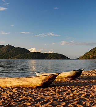 A pair of wooden canoes on the edge of the water of Lake Malawi, Malawi