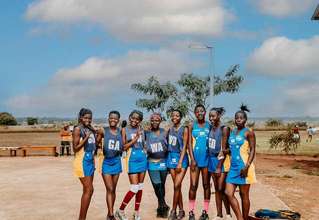 A girls netball local team posing before a game in Malawi