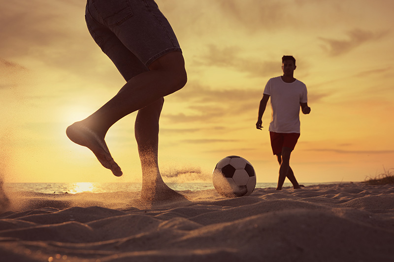 Football beach training at sunset