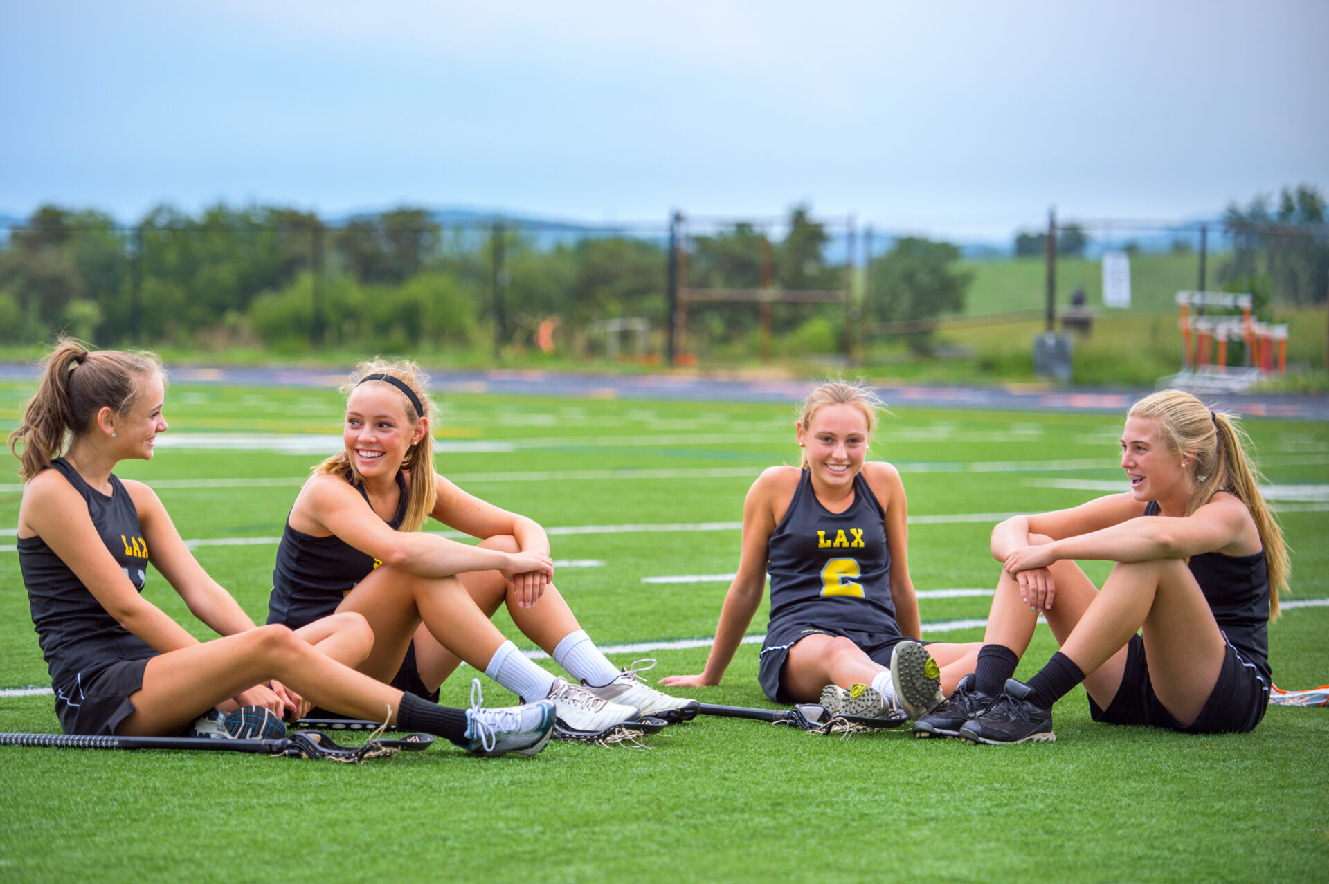 Lacrosse girls team sitting on grass