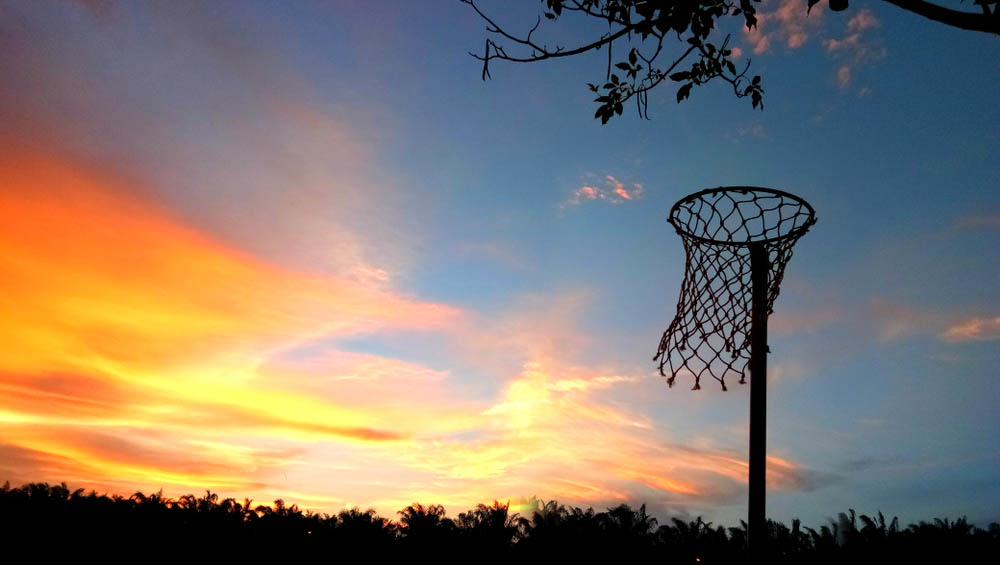 Netball basket against a golden sky at sunset