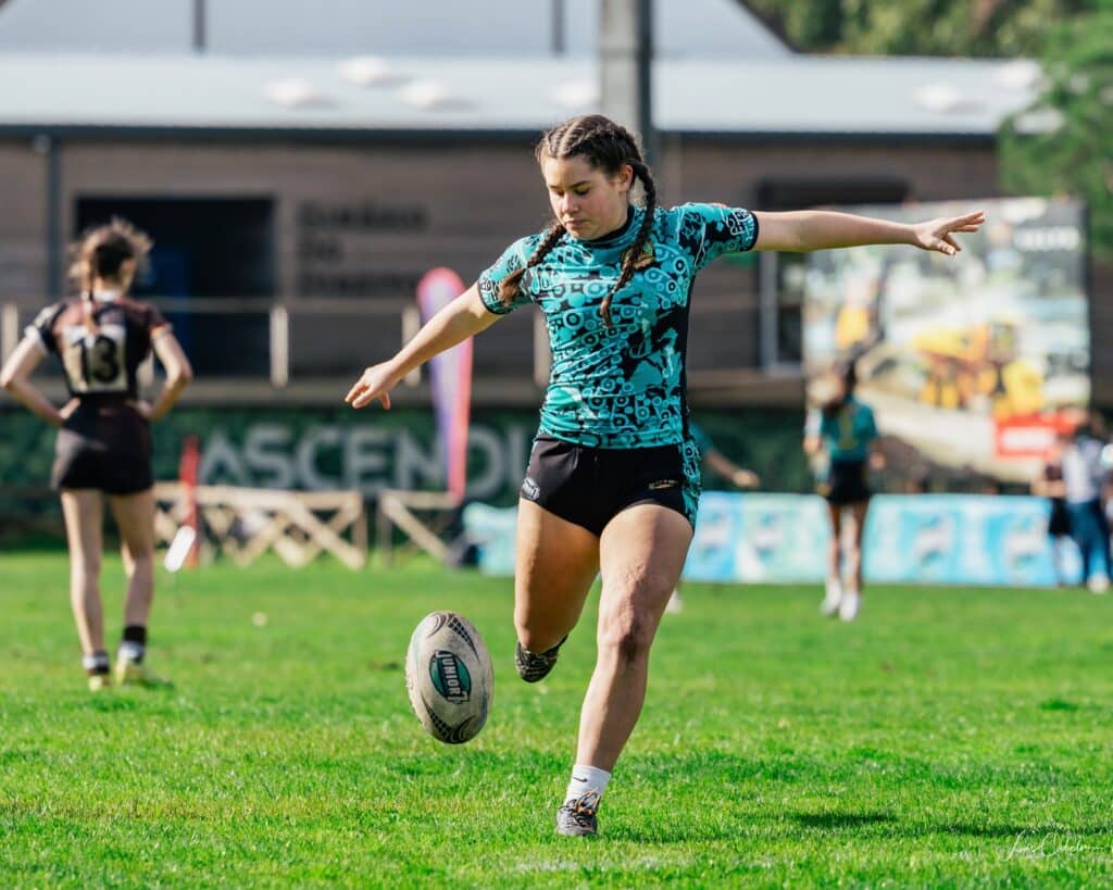 A female rugby player, kicking a Lisbon 7s rugby ball