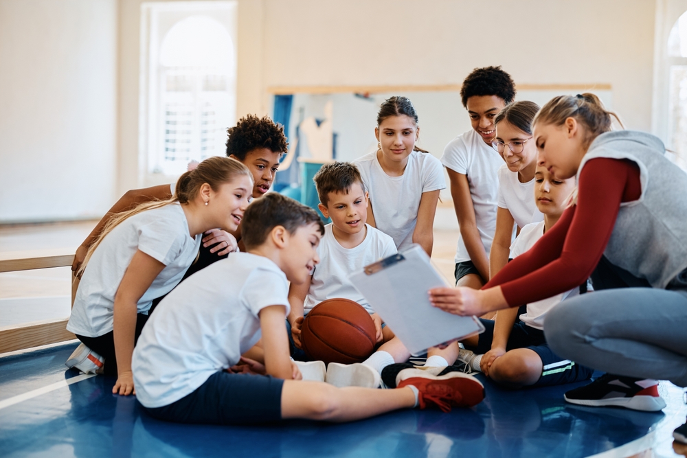 PE teacher showing a board to her students during practice
