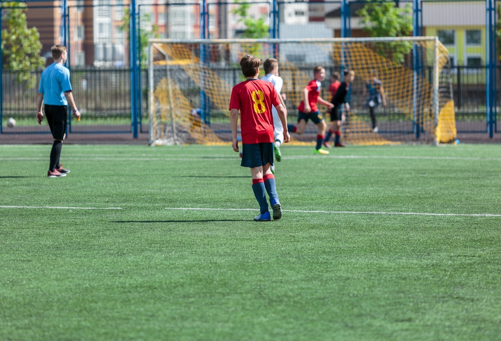 Boys team playing football in red jerseys