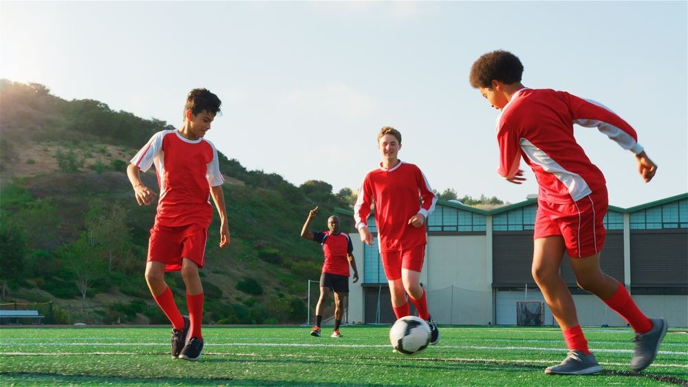 Boys team playing football in red jerseys