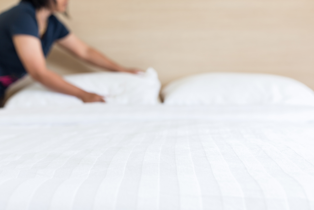 Housekeeper making the bed in a hotel