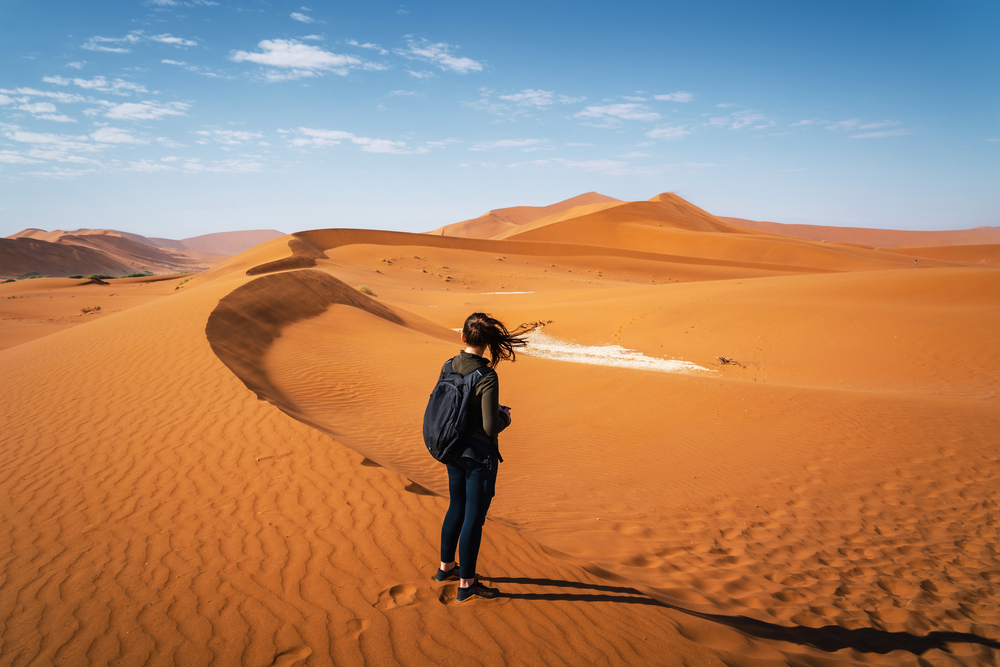Student on a sand dune in the Namib desert, Deadvlei, Namibia