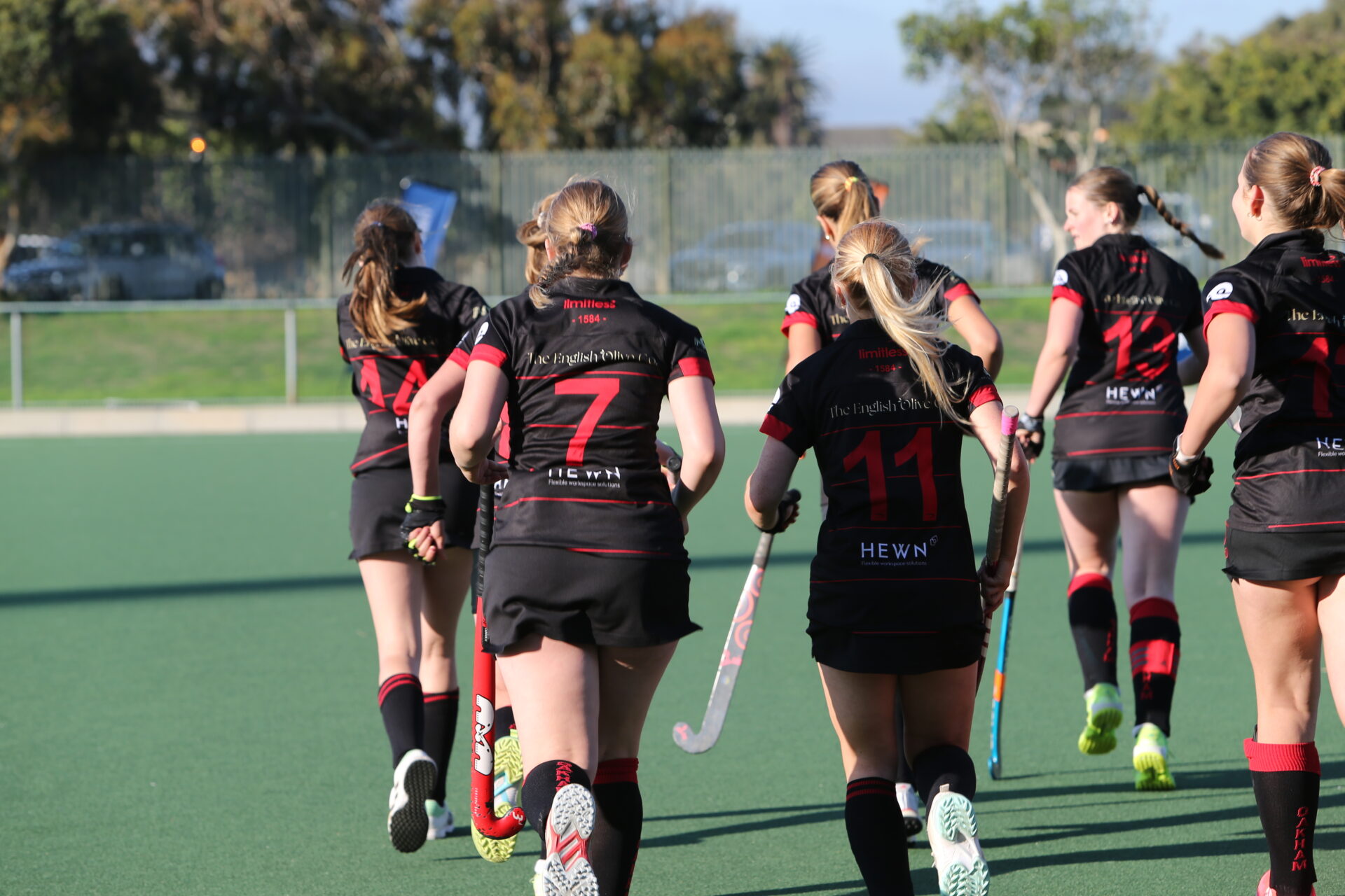Hockey girls team running on the pitch