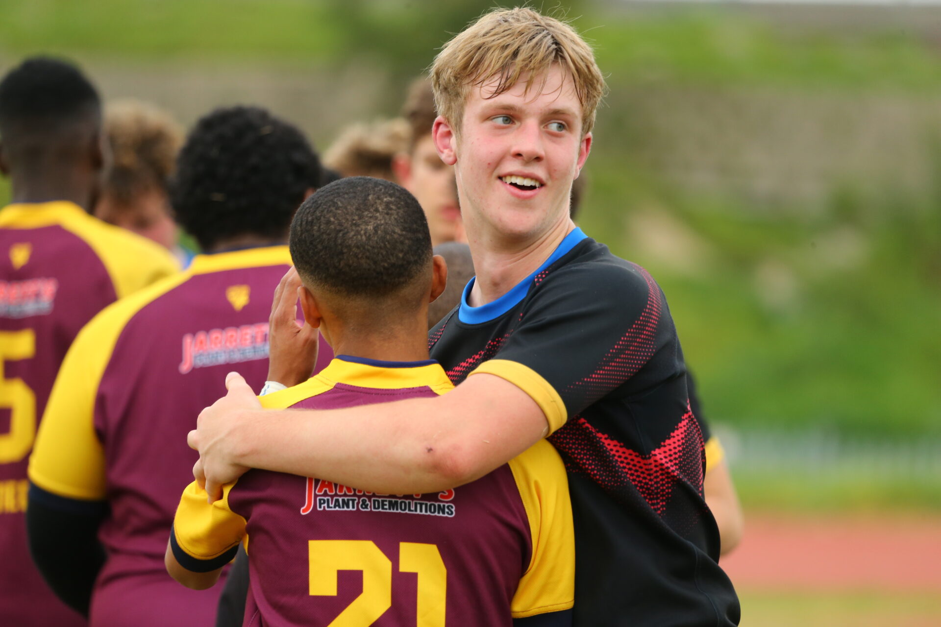 Two competing players having a friendly embrace on the pitch at the Festival of Unity in South Africa