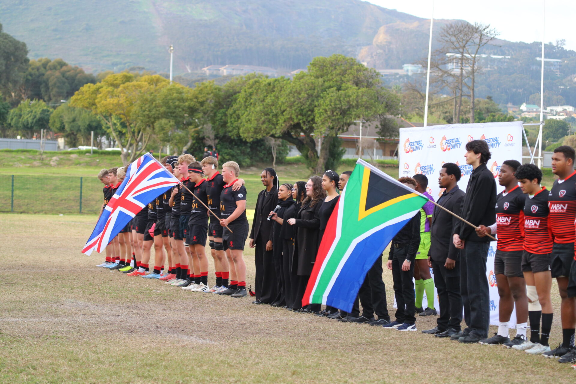 South African and UK teams holding their flags before a rugby match at the Festival of Unity in South Africa